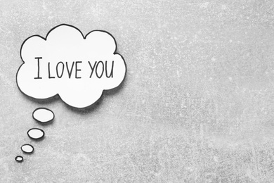 Photo of Paper thought balloon with phrase I Love You on light grey table, flat lay. Space for text