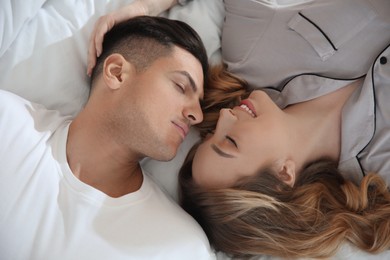 Photo of Lovely couple enjoying time together on bed, above view
