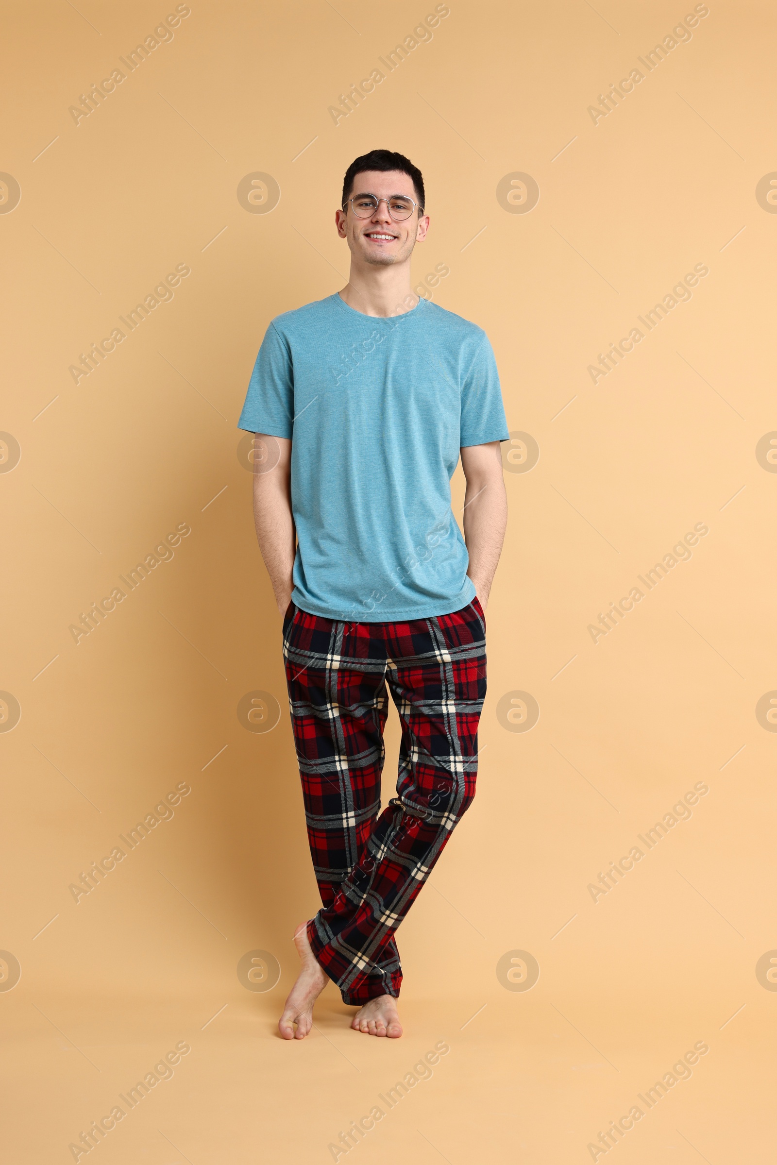 Photo of Happy man in pyjama on beige background