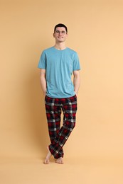 Happy man in pyjama on beige background