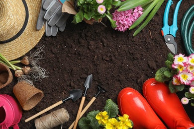 Flat lay composition with gardening equipment and space for text on ground