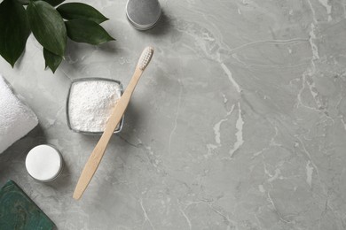 Photo of Flat lay composition with tooth powder and green leaves on light grey marble table, space for text