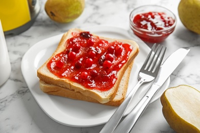 Photo of Slice of bread with jam on white marble table