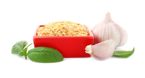 Photo of Bowl of granulated dry garlic and basil on white background