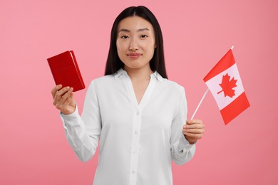 Photo of Immigration to Canada. Woman with passport and flag on pink background