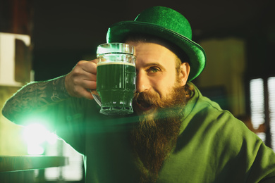 Photo of Man with glass of green beer in pub. St. Patrick's Day celebration