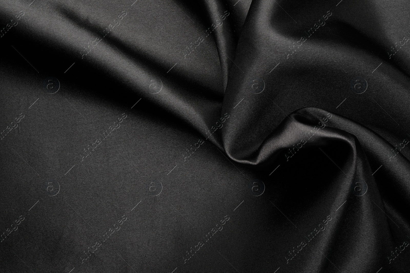 Photo of Crumpled black silk fabric as background, top view