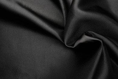 Photo of Crumpled black silk fabric as background, top view