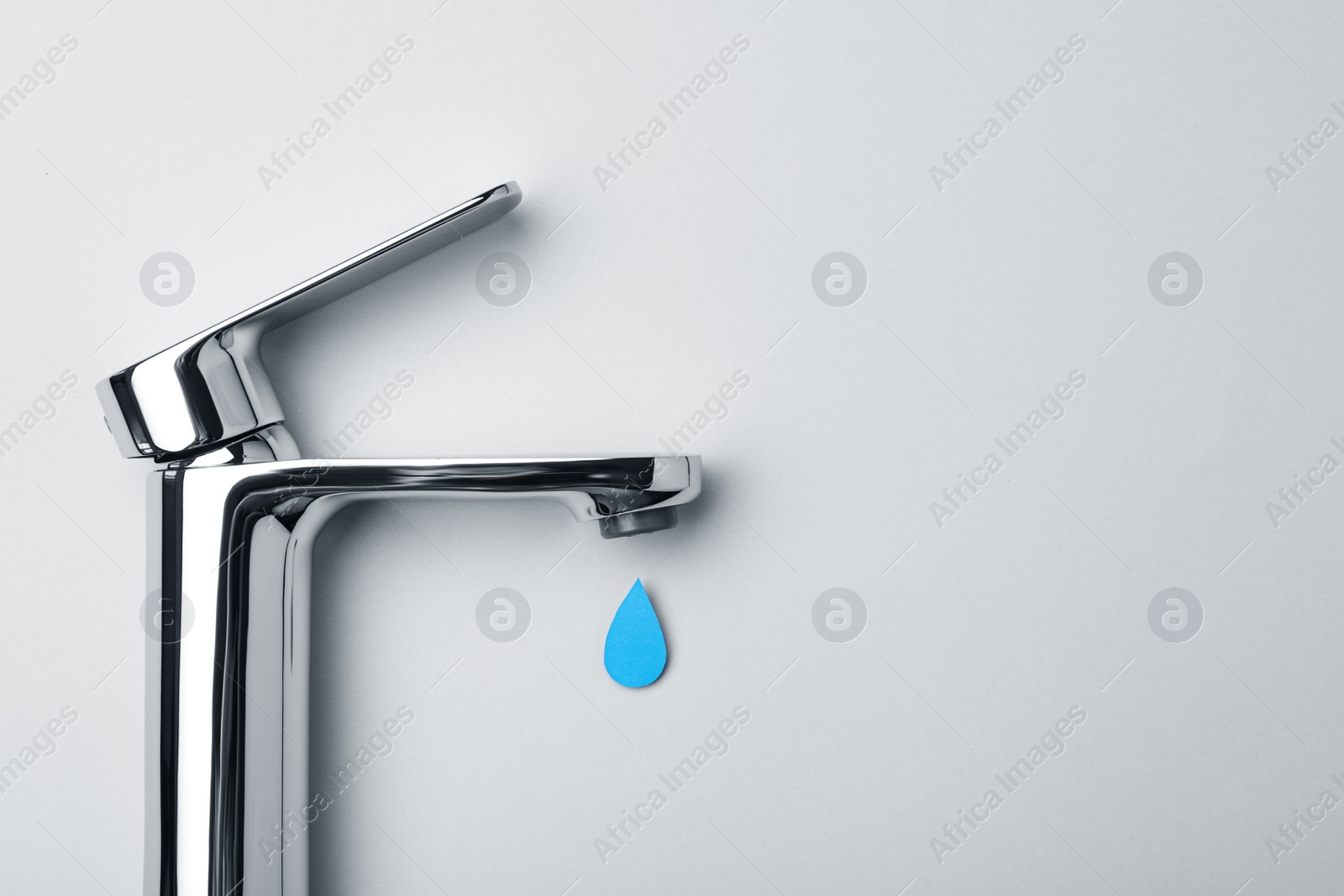 Photo of Paper water drop and modern tap on grey background, flat lay. Space for text