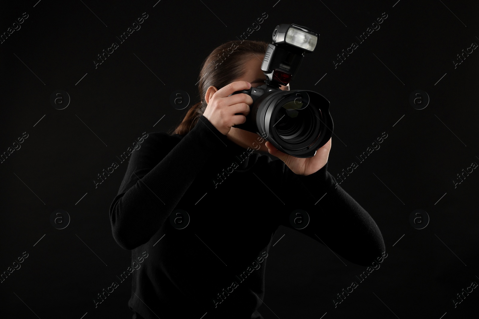 Photo of Professional photographer taking picture on black background