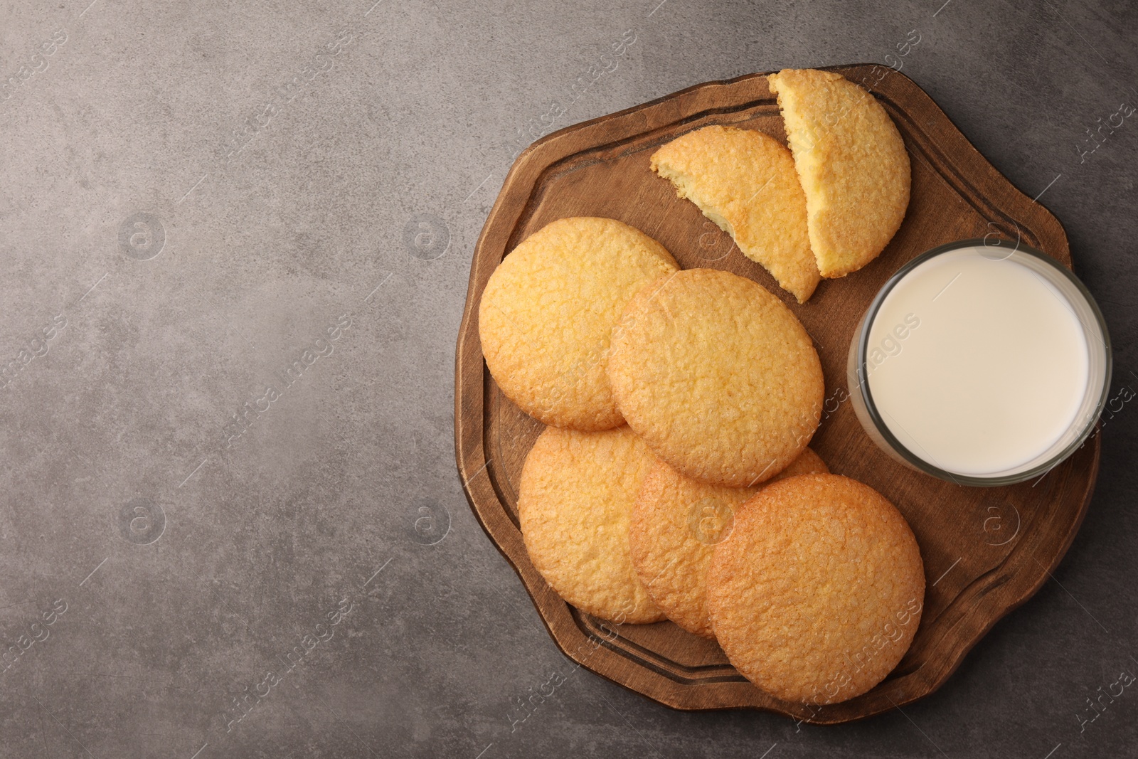 Photo of Delicious Danish butter cookies and milk on grey table, top view. Space for text