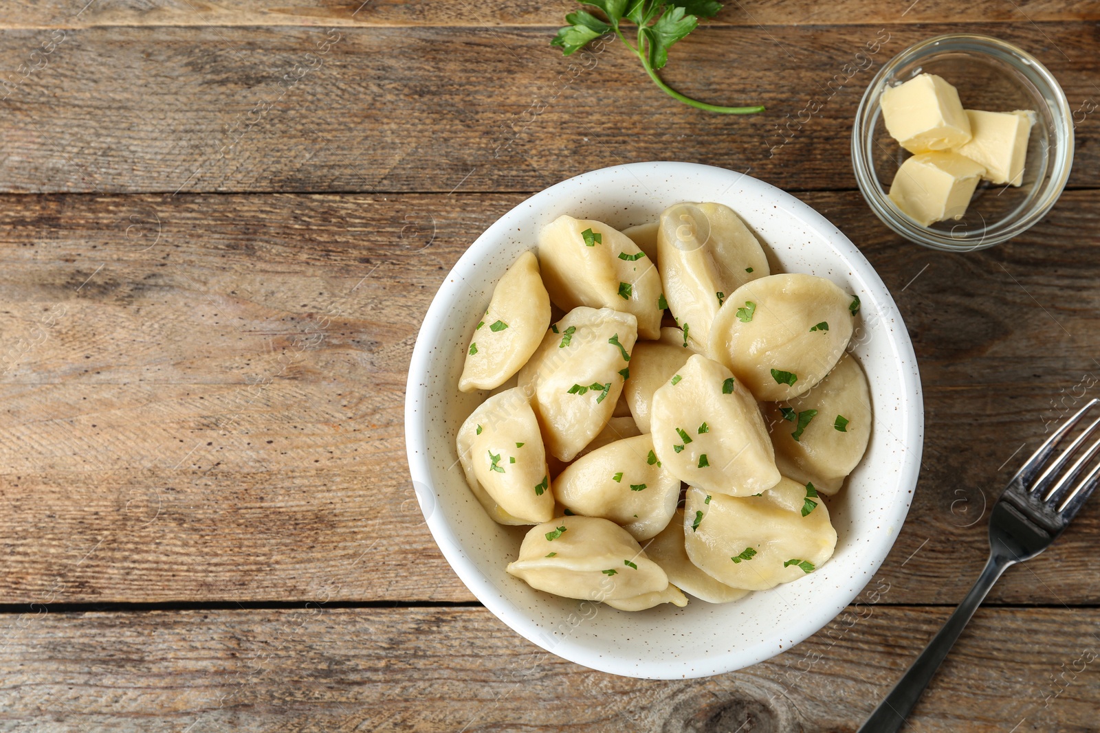 Photo of Delicious cooked dumplings served on wooden table, flat lay. Space for text