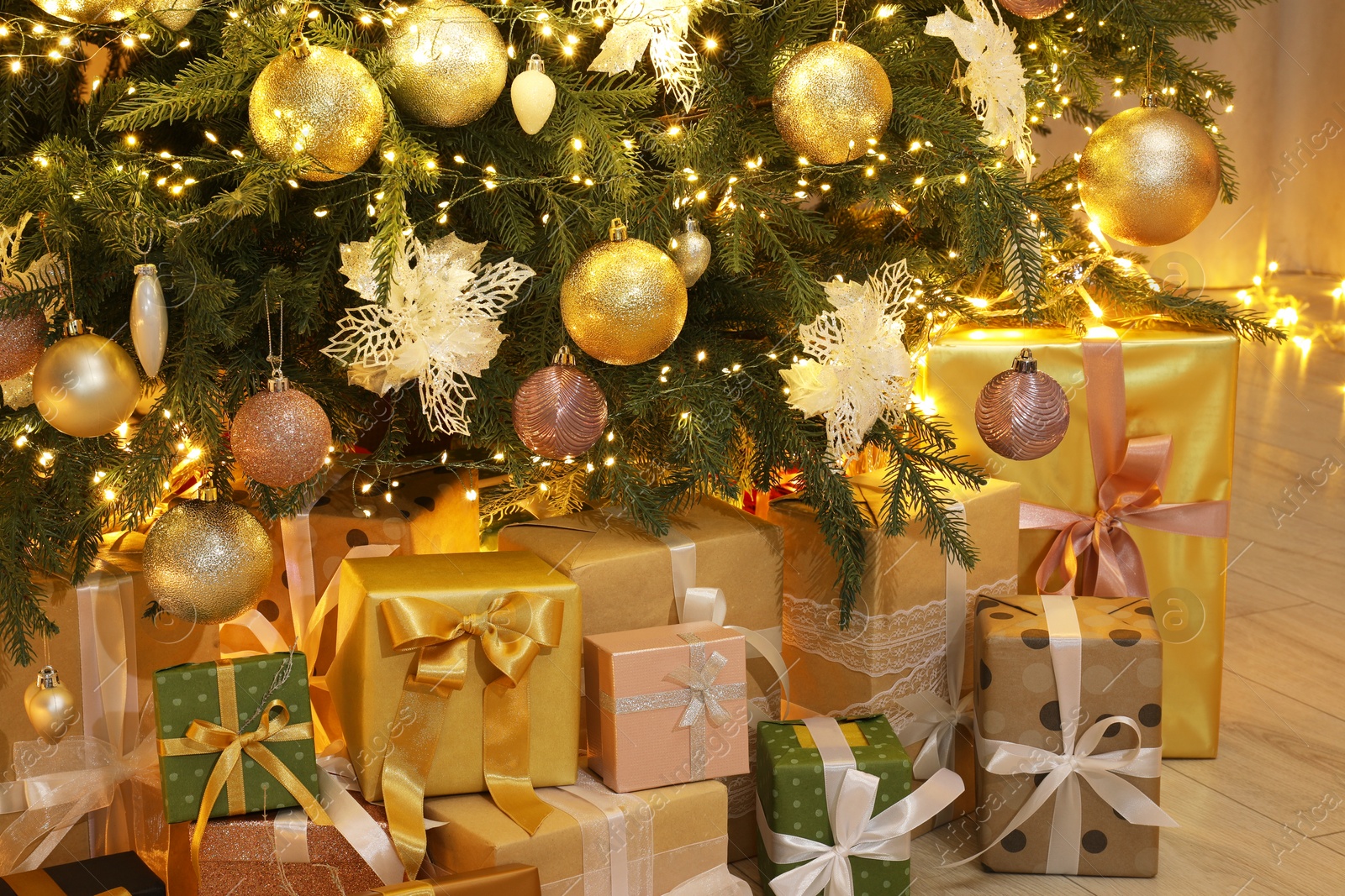 Photo of Many gift boxes under decorated Christmas tree at home