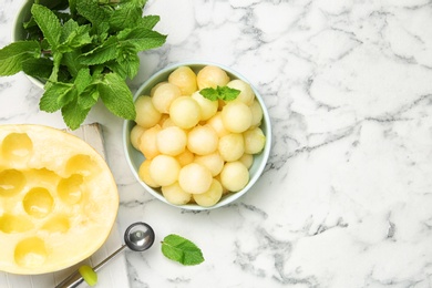 Photo of Flat lay composition with melon balls on white marble table, space for text