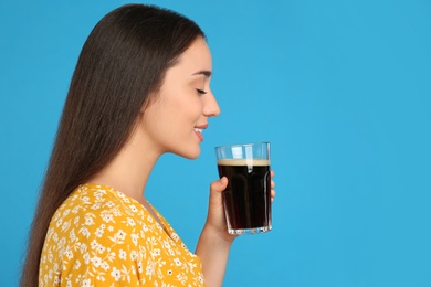 Photo of Beautiful woman with cold kvass on blue background. Traditional Russian summer drink