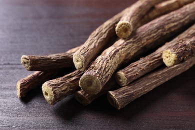 Dried sticks of liquorice root on wooden table, closeup
