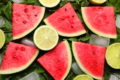 Photo of Tasty sliced watermelon, limes, mint and ice as background, top view