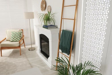 Photo of Wooden ladder near fireplace in stylish room