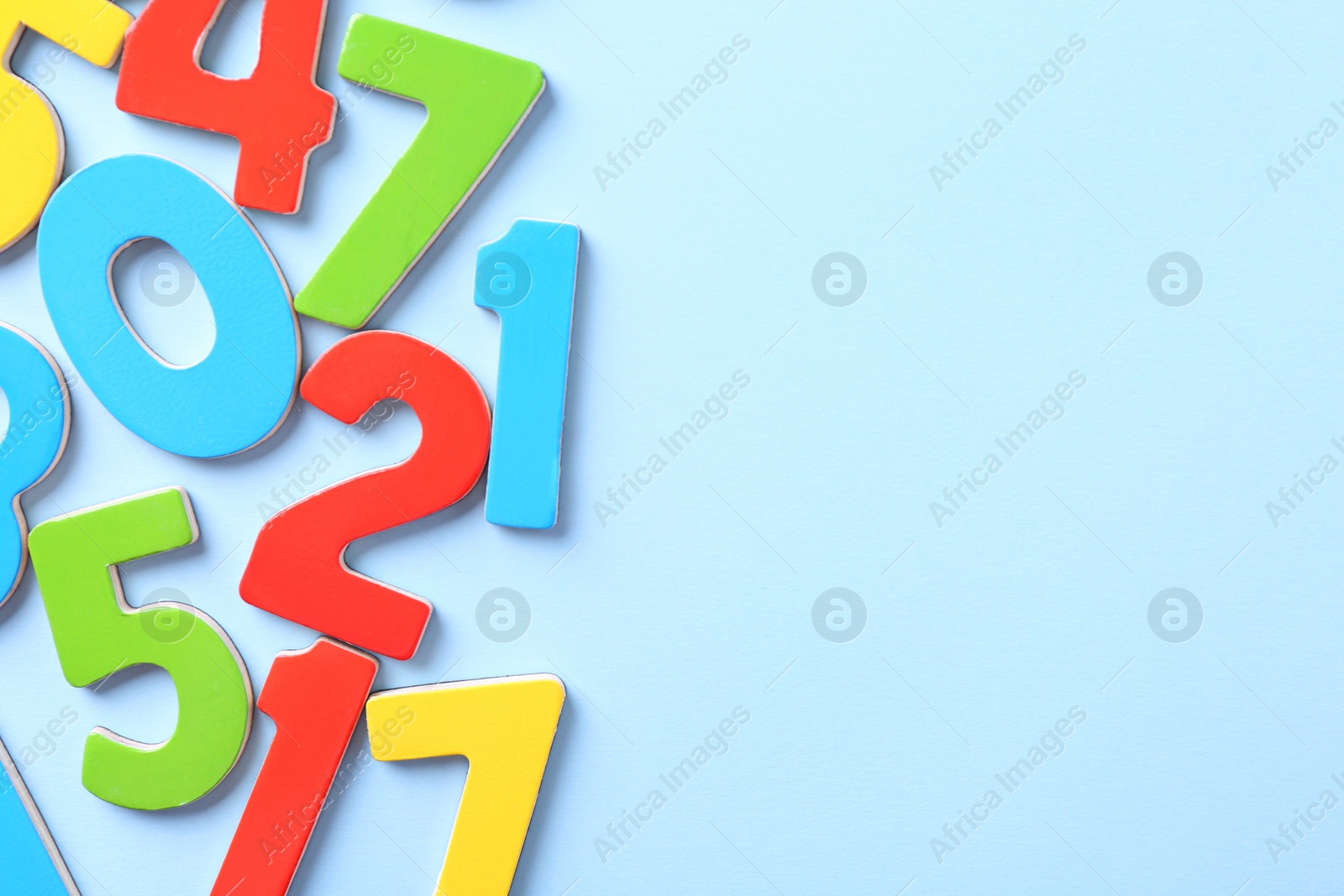 Photo of Colorful numbers on light blue background, flat lay. Space for text