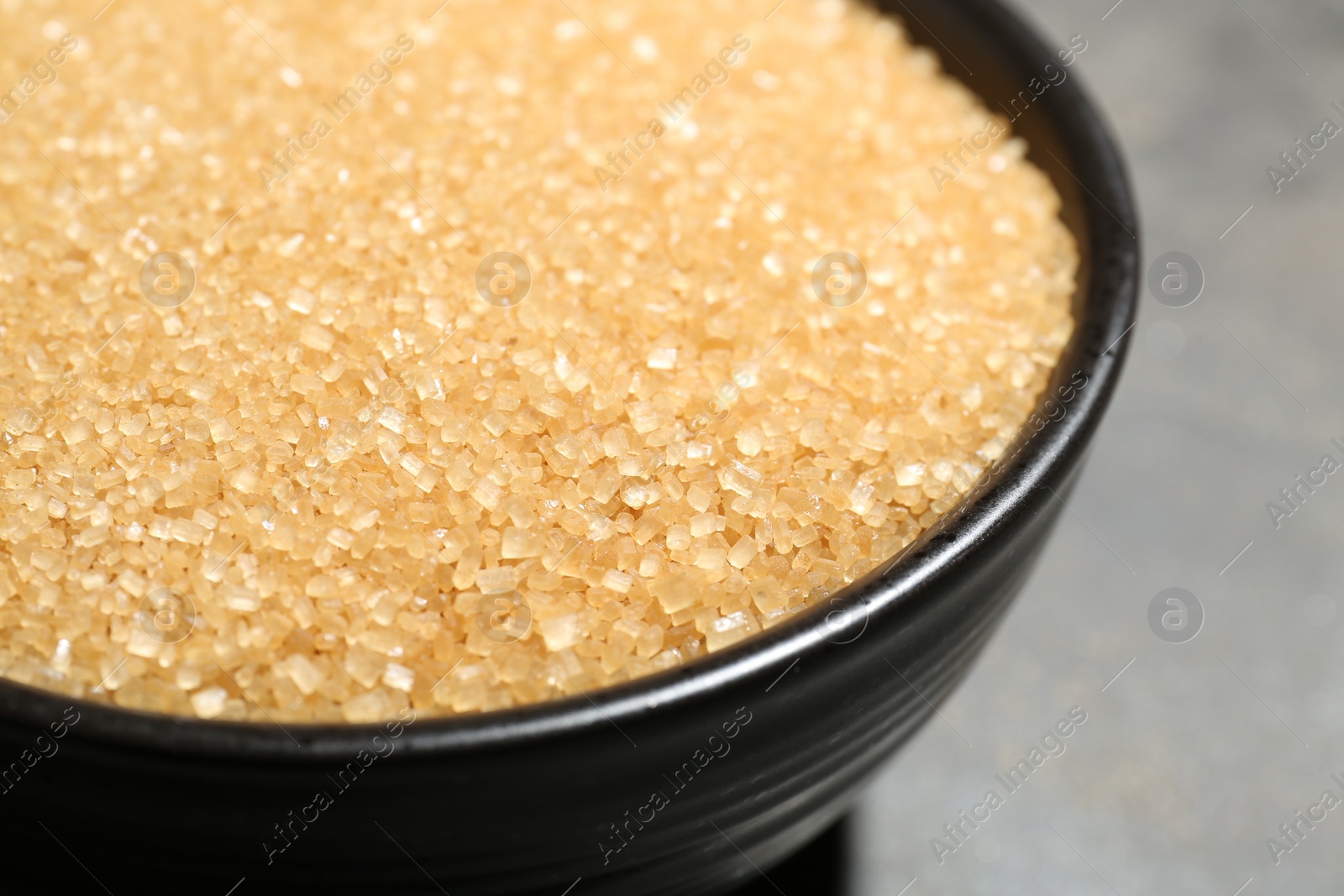 Photo of Brown sugar in bowl on blurred background, closeup