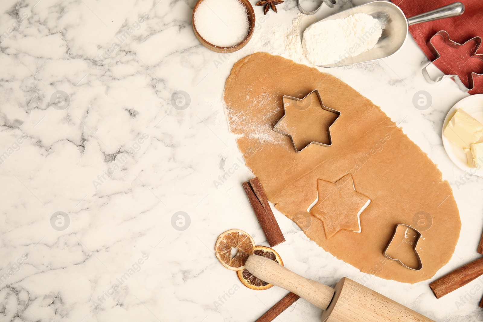 Photo of Raw dough, different cutters and ingredients for Christmas cookies on white marble table, flat lay. Space for text