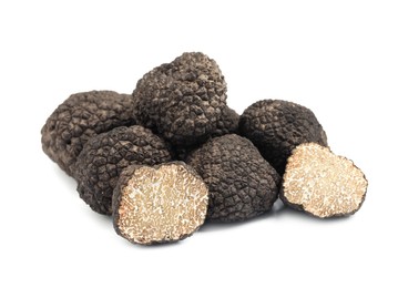 Cut and whole black truffles isolated on white