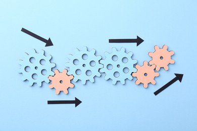 Photo of Business process organization and optimization. Scheme with wooden figures and arrows on light blue background, top view