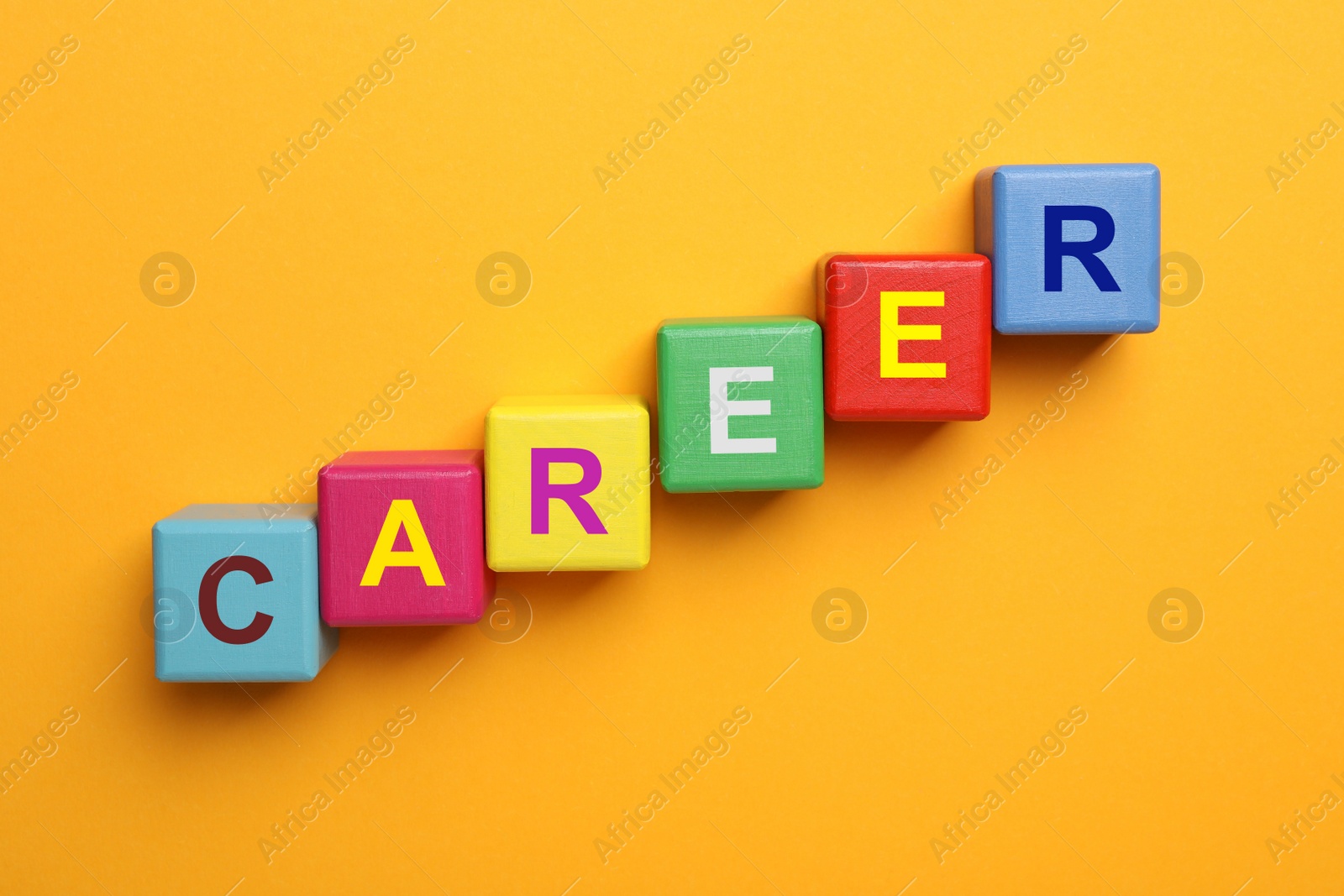 Photo of Colorful cubes with word CAREER on orange background, flat lay