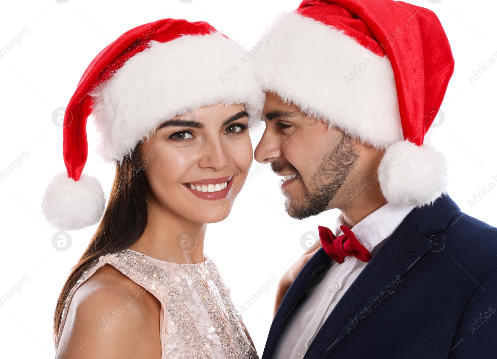 Photo of Lovely young couple in Santa hats on white background. Christmas celebration