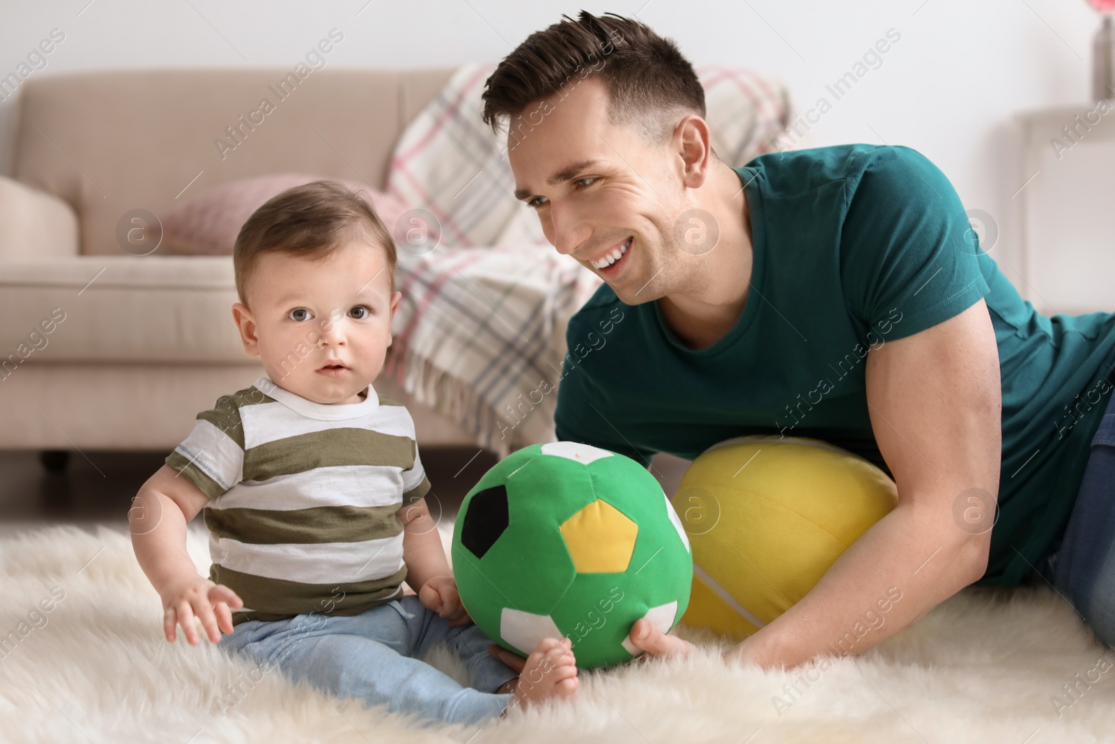 Photo of Young father with his cute little son at home