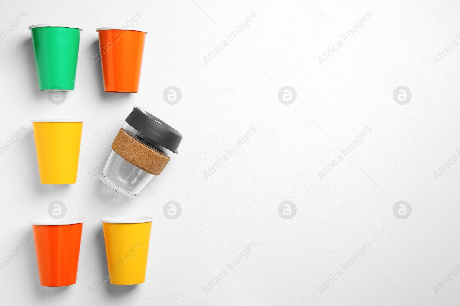 Photo of One reusable and other disposable cups on white background, flat lay. Space for text