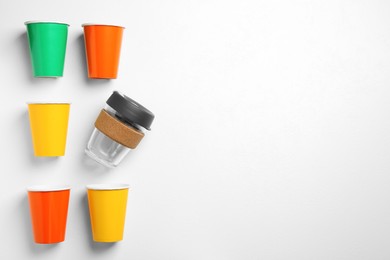One reusable and other disposable cups on white background, flat lay. Space for text