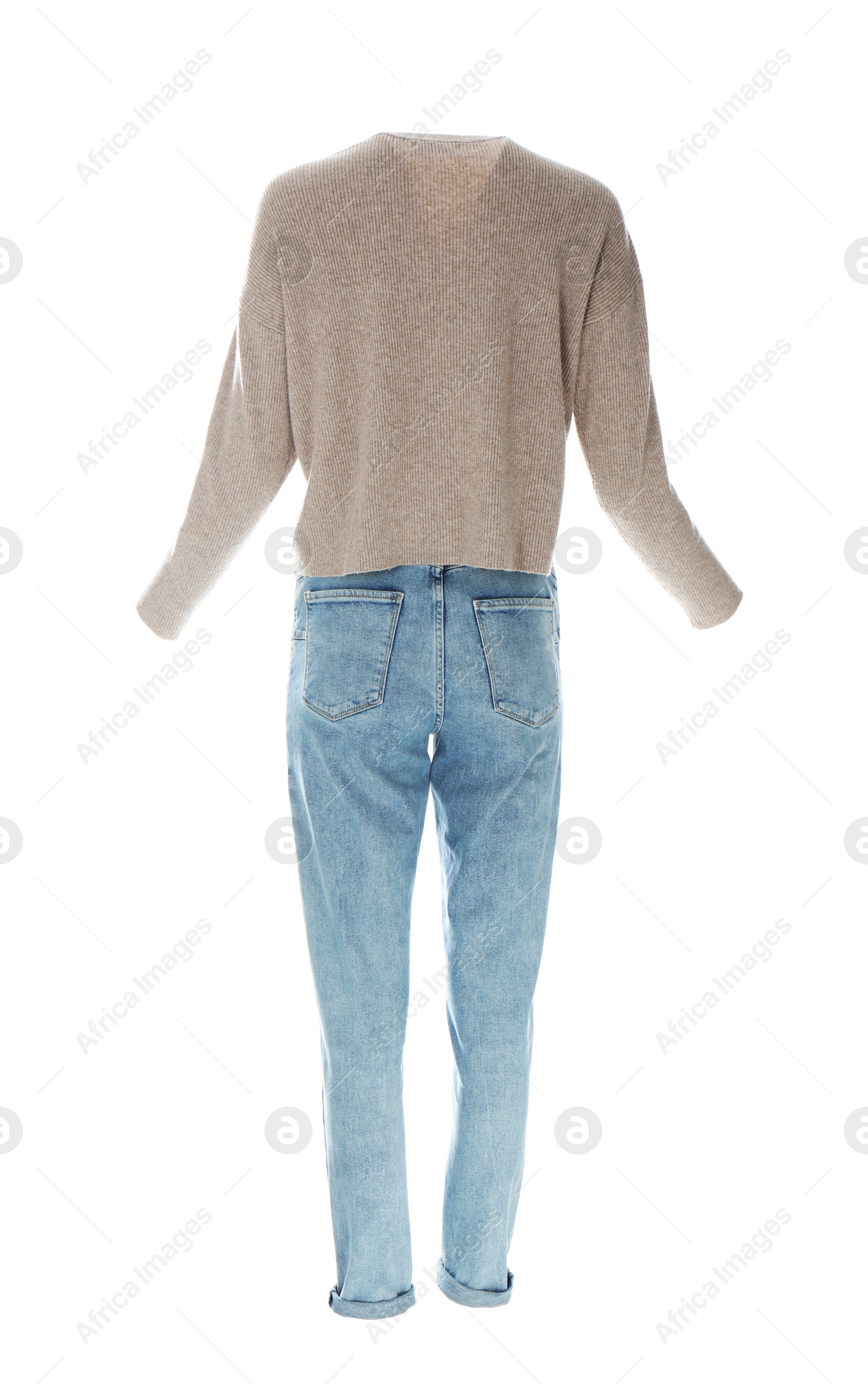 Photo of Stylish jeans and sweater on mannequin against white background. Women's clothes