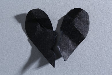 Halves of torn paper heart on gray background, top view. Breakup concept