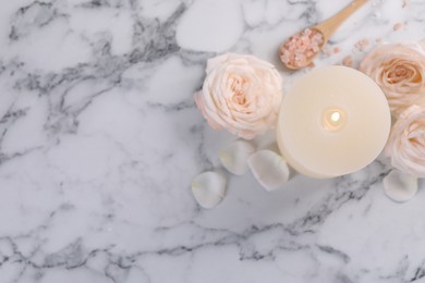 Spa composition with burning candle, flowers and sea salt on white marble table, flat lay. Space for text