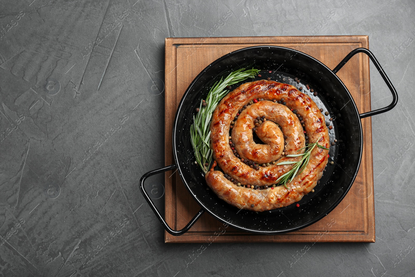 Photo of Tasty homemade sausages with spices on grey table, top view. Space for text
