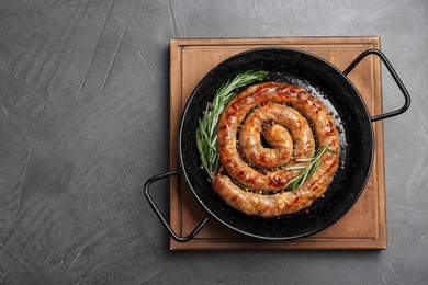 Tasty homemade sausages with spices on grey table, top view. Space for text