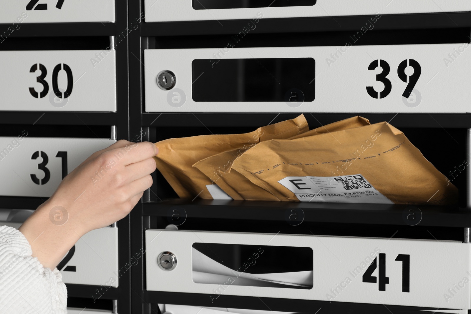 Photo of Woman taking envelope out of mailbox, closeup