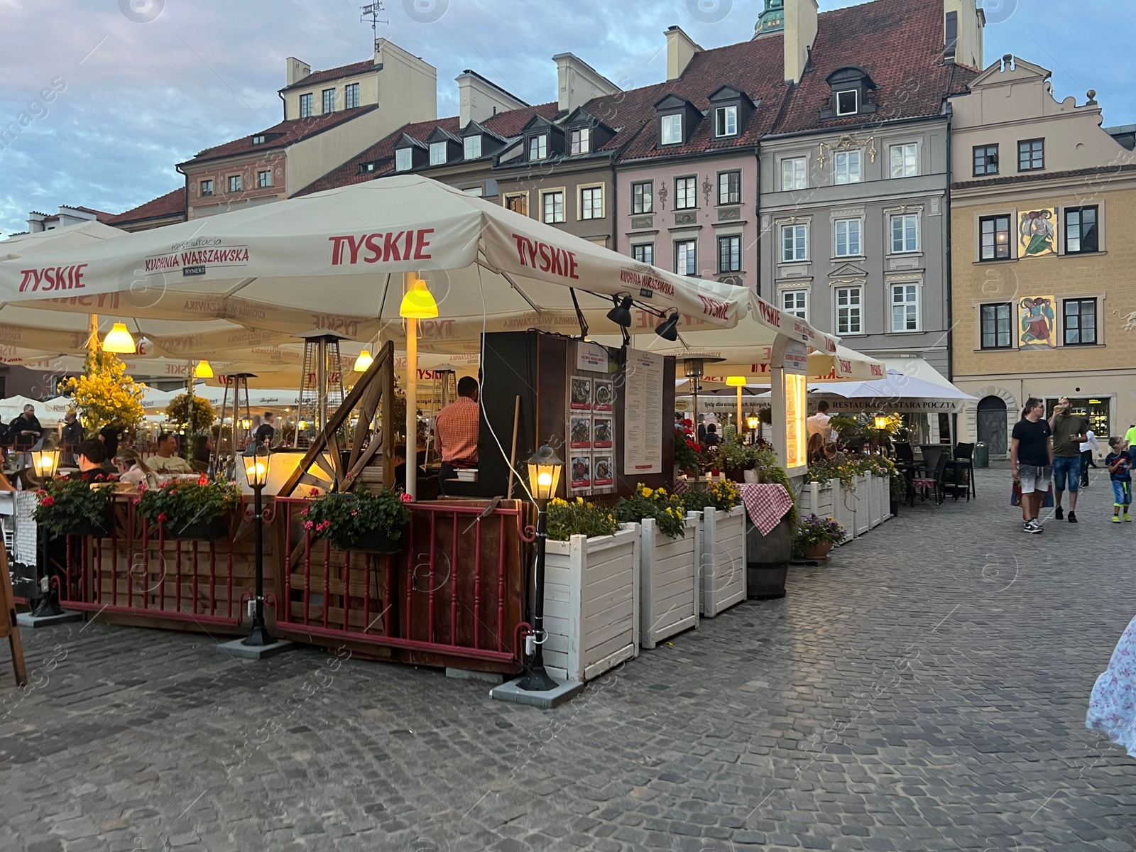 Photo of WARSAW, POLAND - JULY 15, 2022: Outdoor cafe terrace on Crowded Old Town Market Place in evening