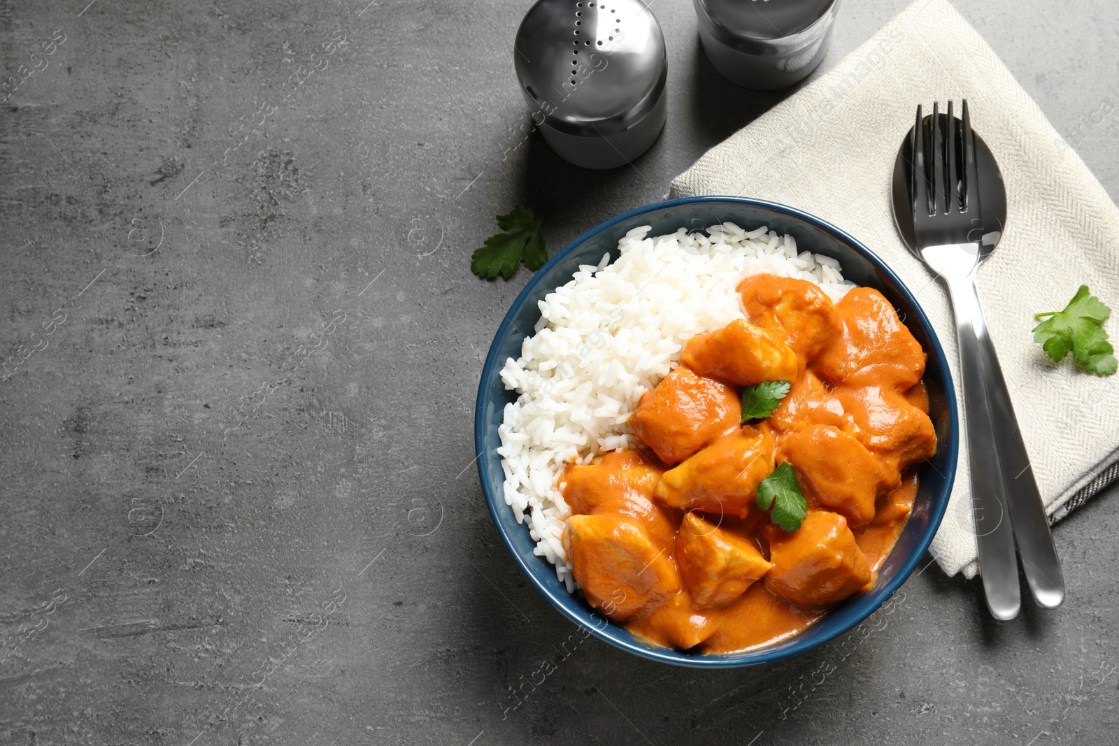 Photo of Butter chicken with rice served on grey table, flat lay. Space for text