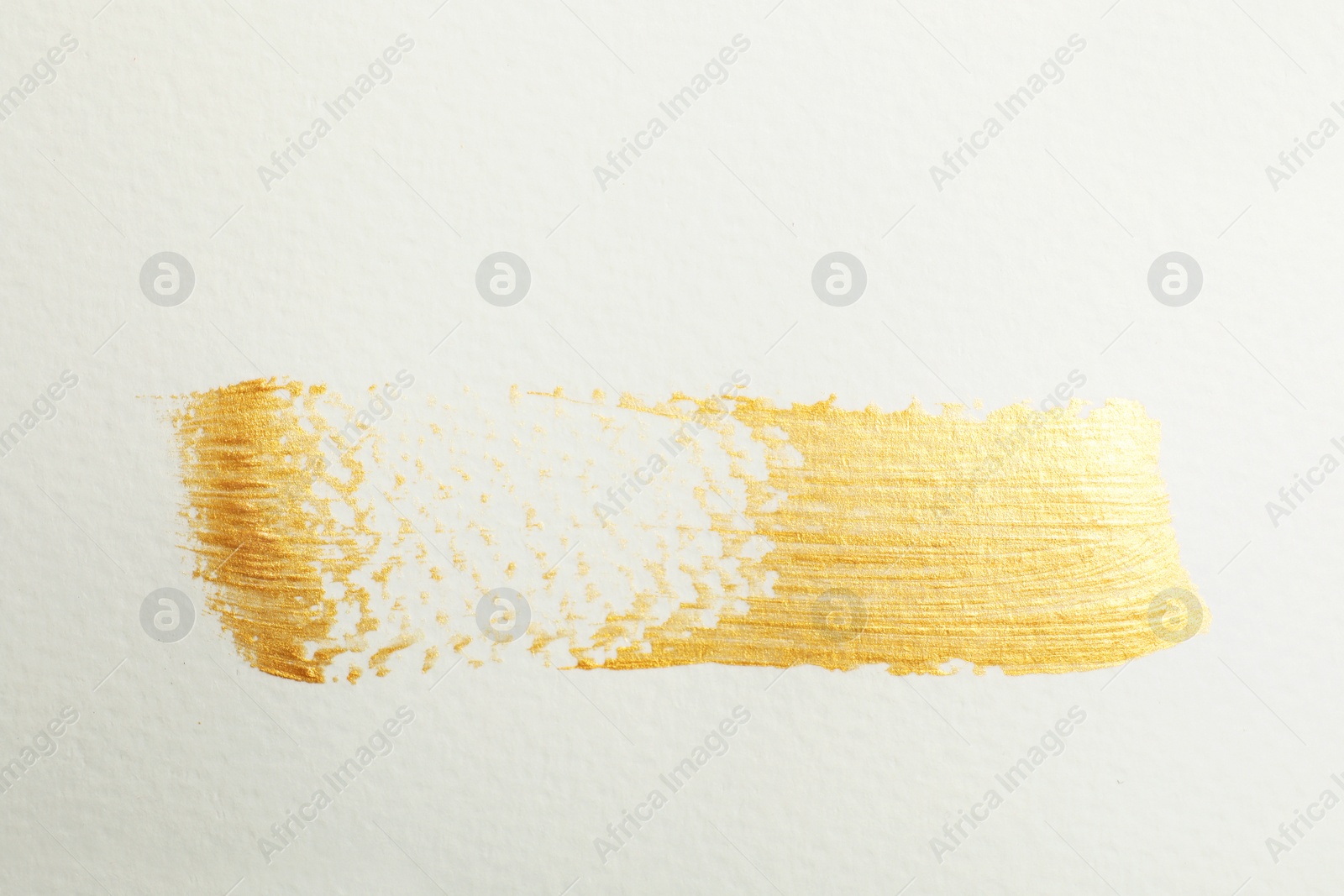 Photo of Golden paint brush stroke on white background