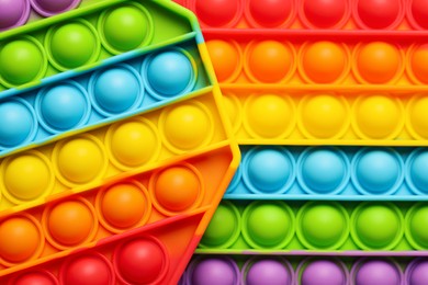 Photo of Rainbow pop it fidget toys as background, closeup