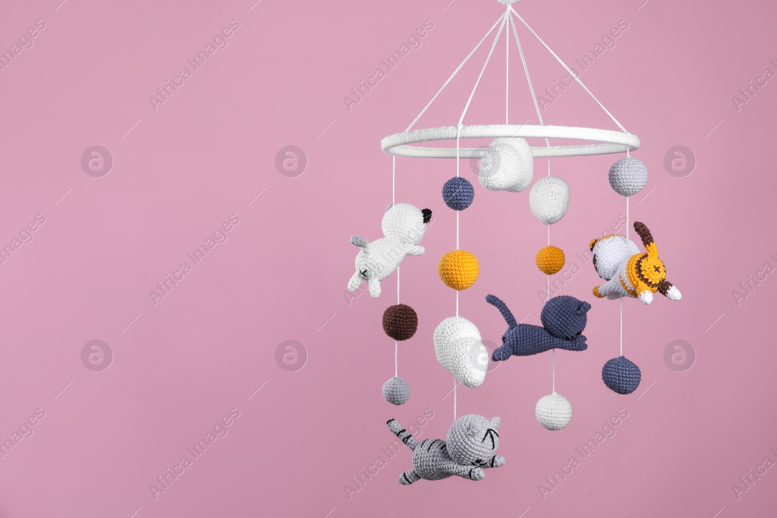 Photo of Cute baby crib mobile on pink background. Space for text
