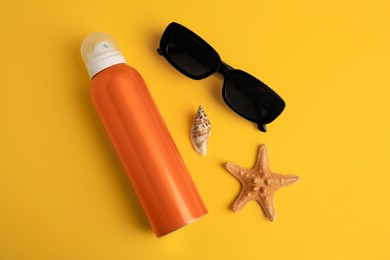 Flat lay composition with bottle of sunscreen on yellow background