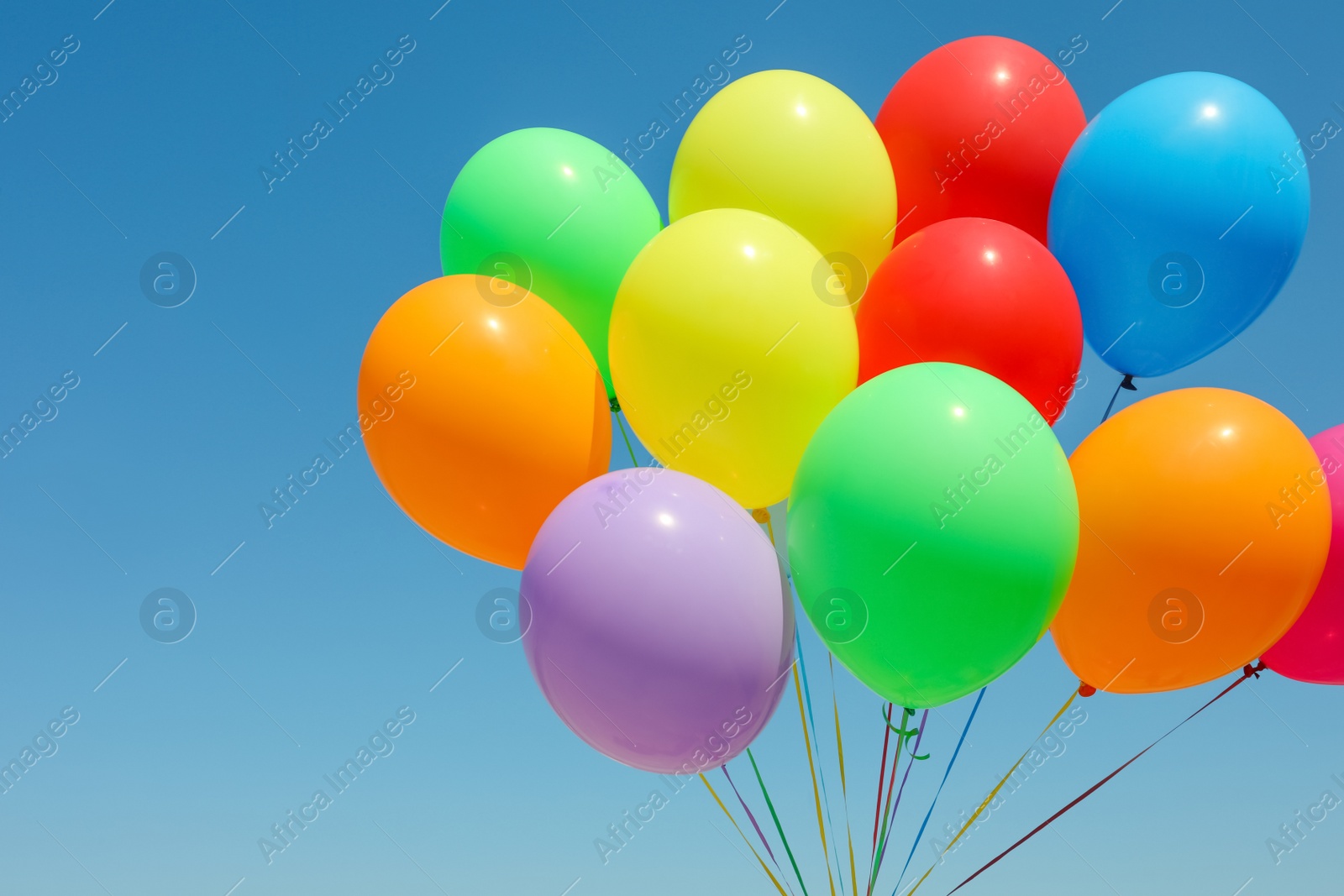 Photo of Bunch of colorful balloons against blue sky