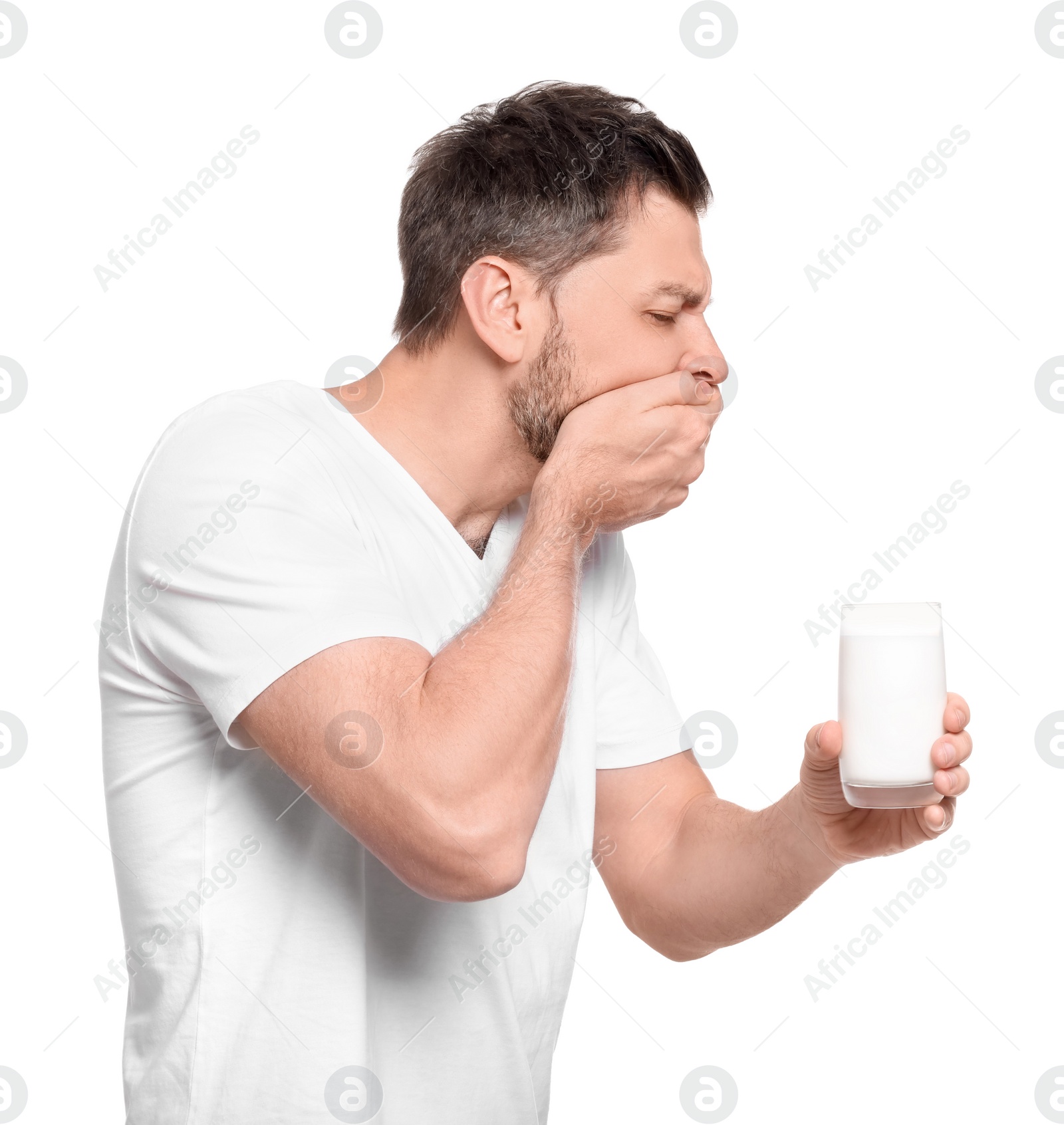 Photo of Man with glass of milk suffering from lactose intolerance on white background