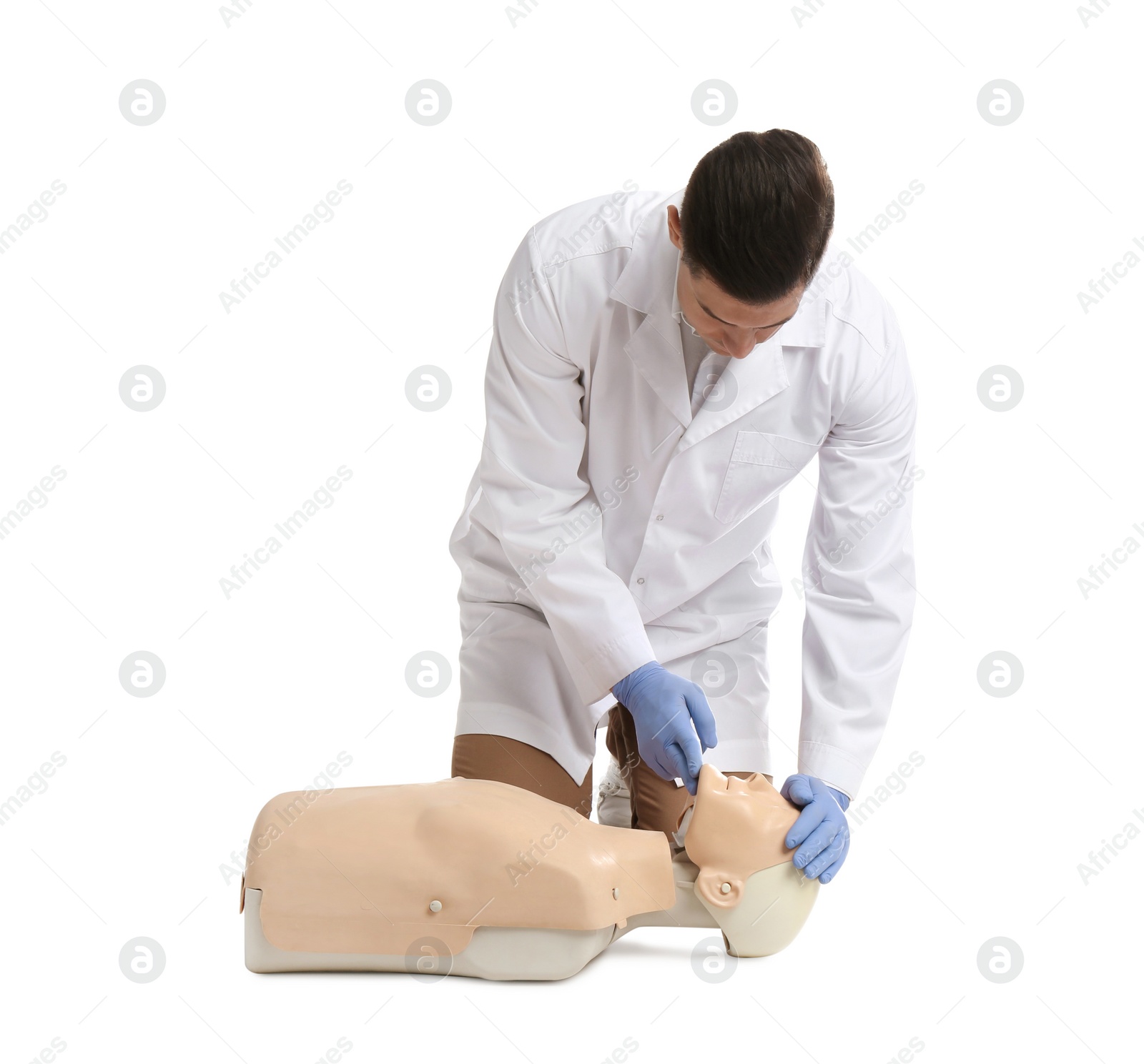 Photo of Doctor in uniform practicing first aid on mannequin against white background