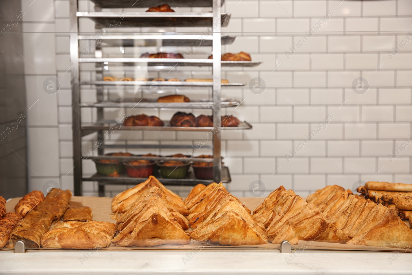 Photo of Fresh pastries on counter in bakery store. Space for text