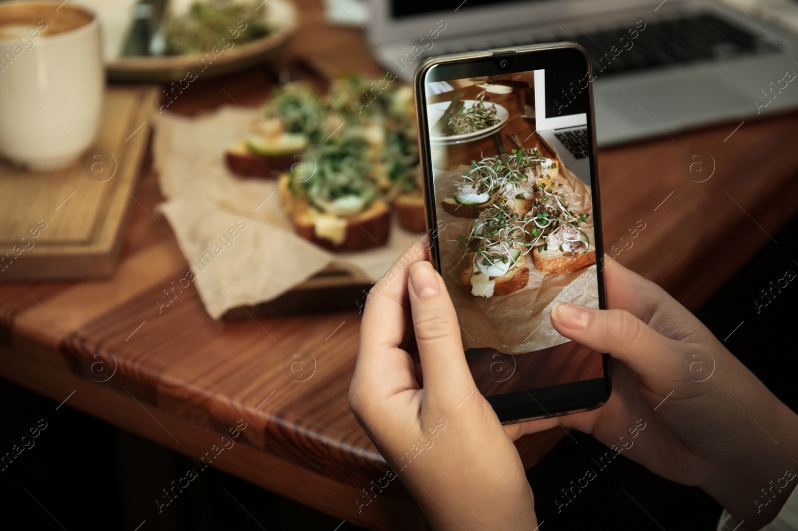 Photo of Food blogger taking photo of her lunch at cafe, closeup