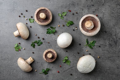 Flat lay composition with fresh champignon mushrooms on grey background